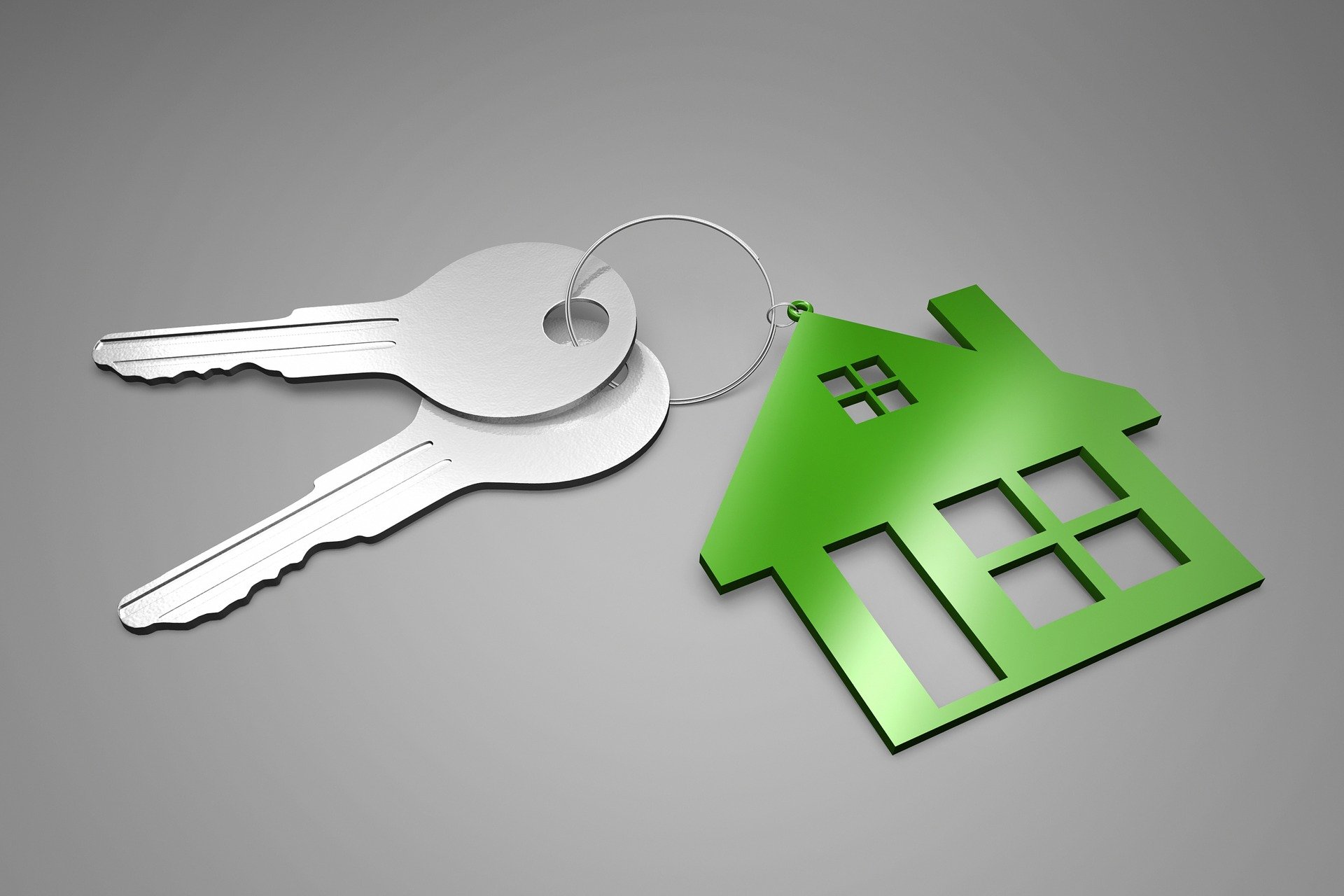 Två nycklar och en grön nyckelbricka som liknar ett hus