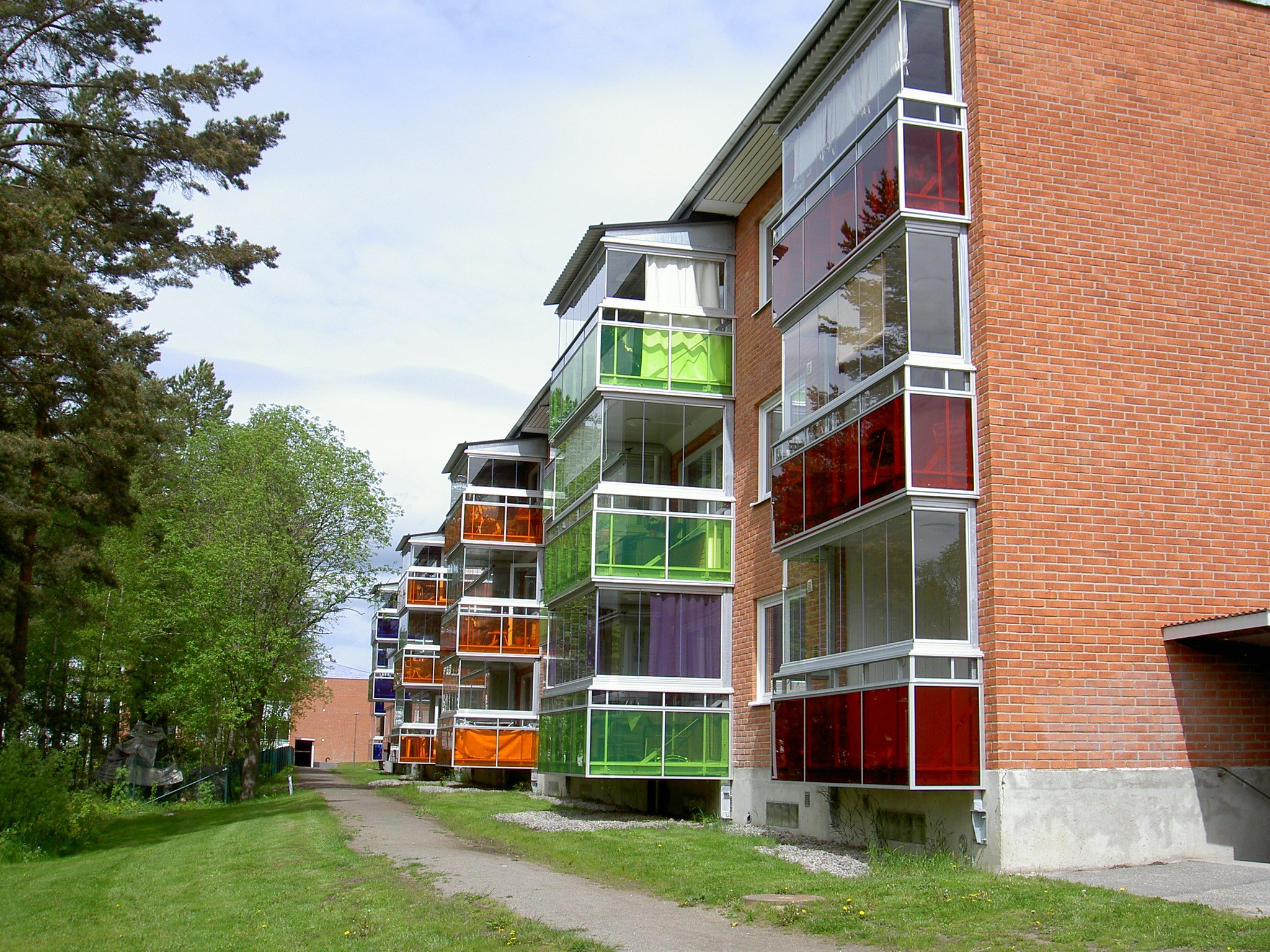 Fasadbild på inglasade balkonger i många olika färger på Gärdeåsvägen 16 i Ljusdal.