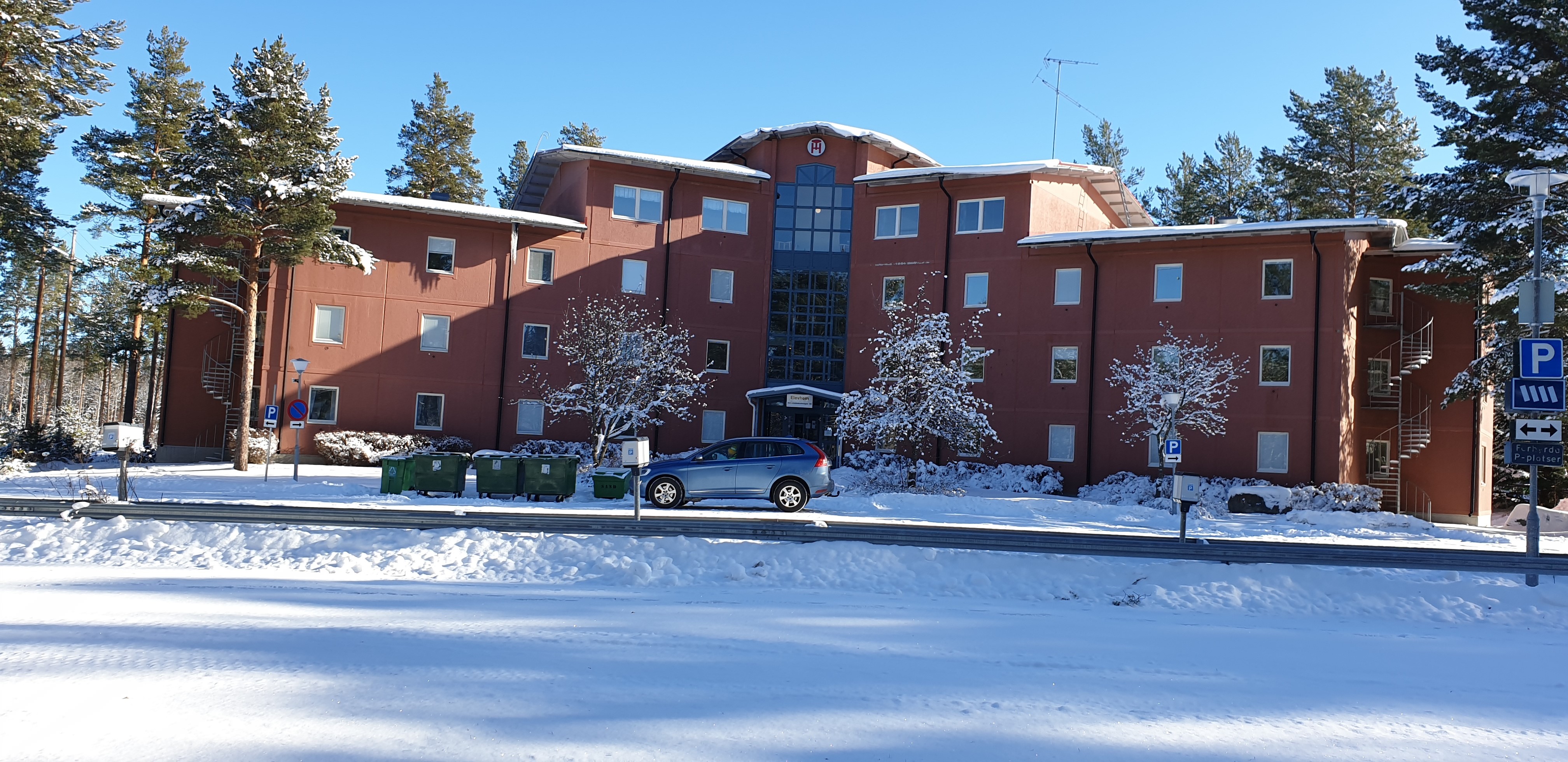 Vinterbild på elevhemmet i Ljusdal. En röd tegelbyggnad i fyra våningar.